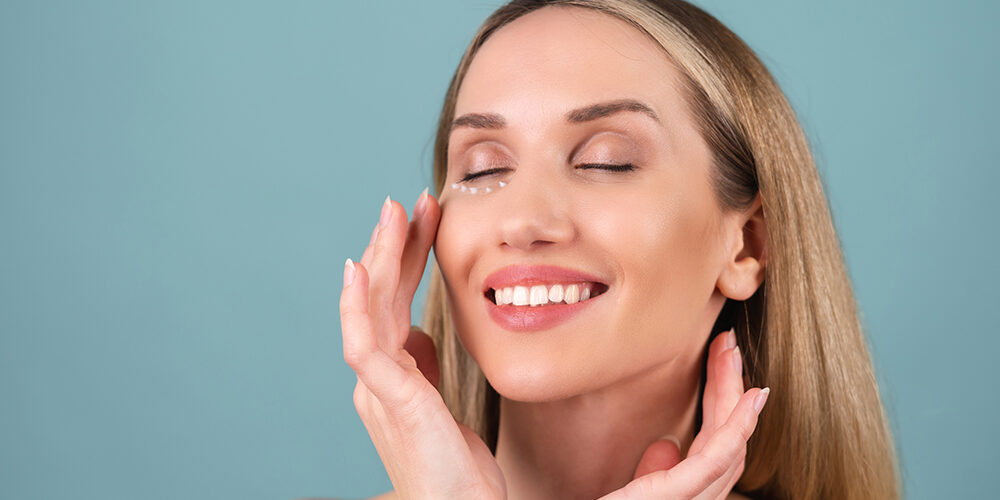 Close-up beauty portrait of a topless woman with perfect skin and natural make-up, with anti-aging cream dots to moisturize and firm the skin under the eyes