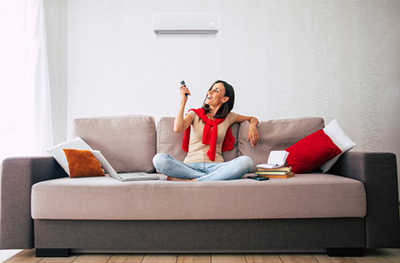 Modern brunette woman is using air conditioner