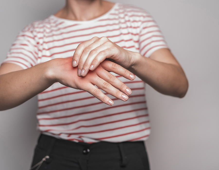 young woman having pain hand against gray background