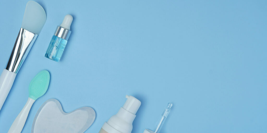 cosmetic accessories on a blue background. facial wash brush, go