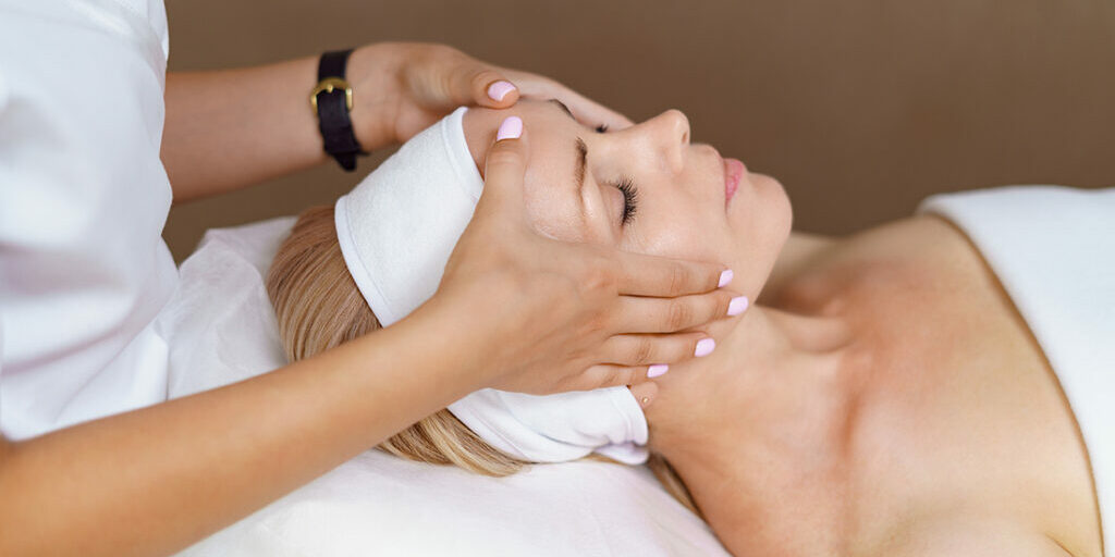 Face massage. Close-up of adult woman getting spa massage treatment at beauty spa salon. Spa skin and body care. Facial beauty treatment. Cosmetology.
