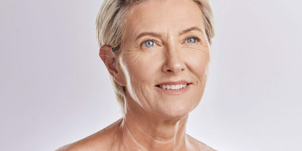 Skincare, beauty and wellness in retirement, a senior woman isolated against a pink background in a studio. Happy elderly female with a good skin care and healthy routine is self care for your face